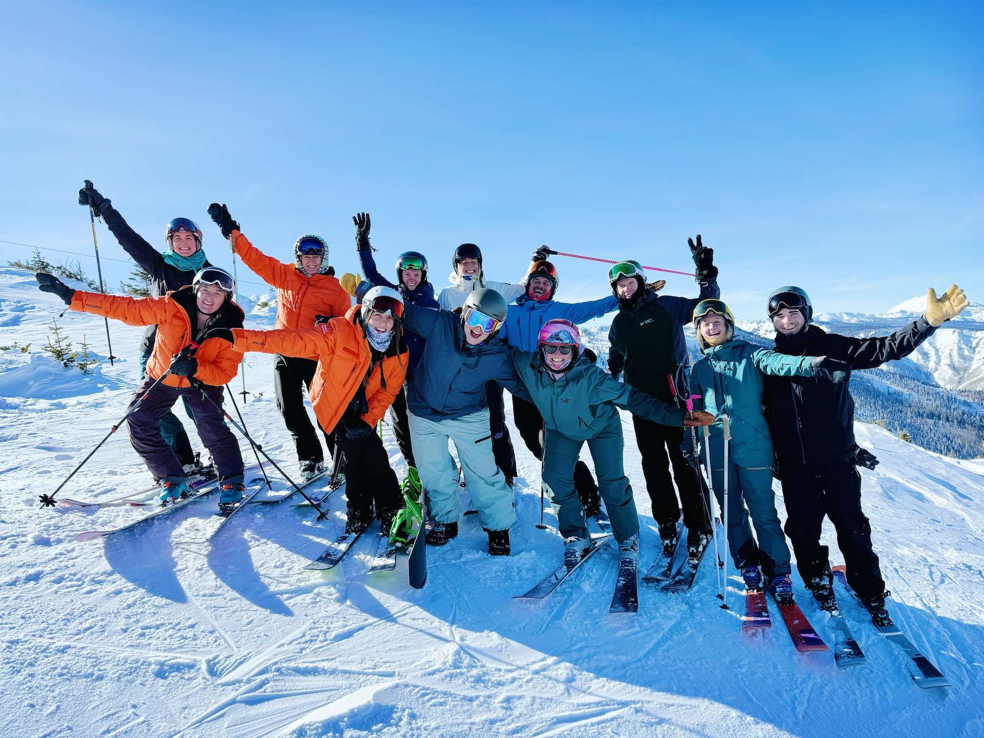 Challenge Aspen staff on a ski day with their hands up in the air.