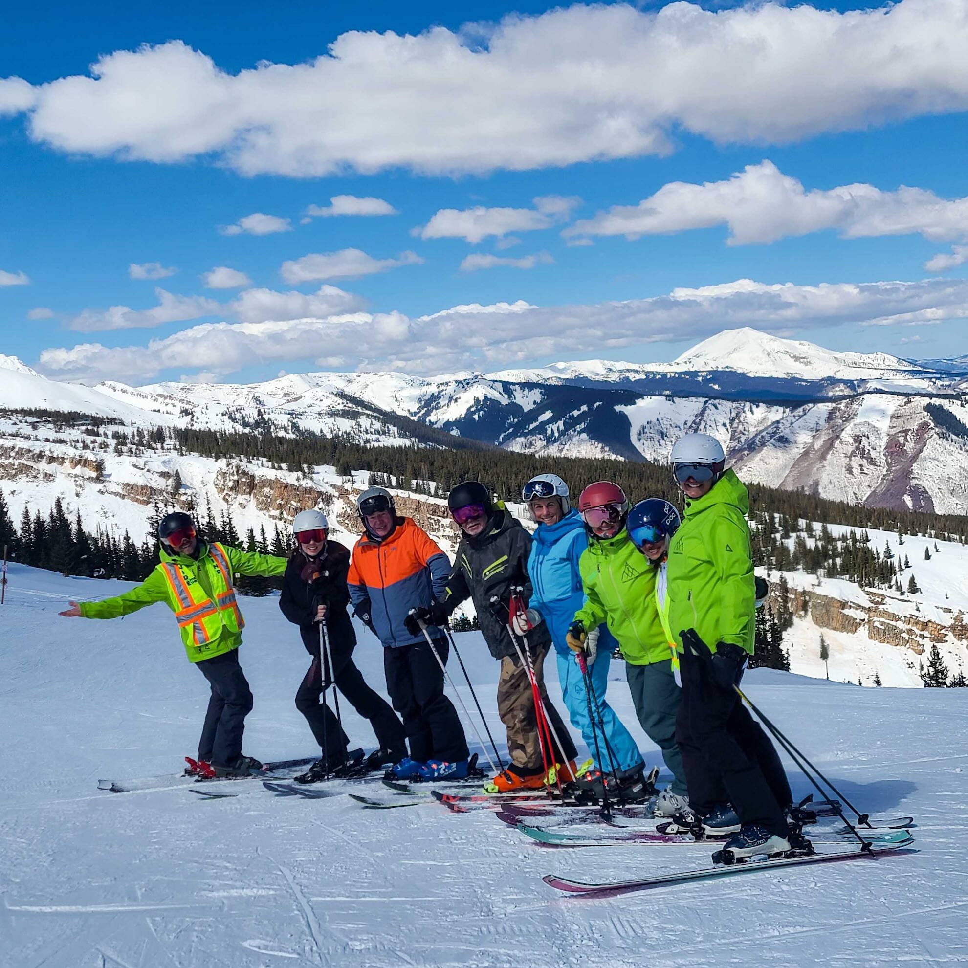 A ski instructor in red bucketing a sitskier down the hill